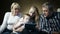 Family watching boy playing game on touchpad