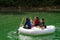 Family wearing life jackets paddling on an inflatable boat in Kenyir Lake, Malaysia