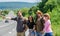 Family weekend. Begin great adventure in your life with hitchhiking. Company friends travelers hitchhiking at edge road