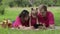 Family weekend picnic. Daughter child girl with mother and father browsing on internet on tablet