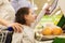 Family weighing oranges on scale at grocery store