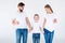 Family in white t-shirts standing together and holding toothbrushes