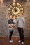 Family woman and siblings teenager and toddler stand indoors near the huge clock 5 minutes before midnight christmas