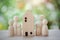 Family wooden dolls standing near wooden house for concept strong family, safe zone stay home, loan