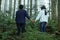 Family in the woods. Brother and sister holding hands from the back in the misty forest. Love friendship, care support.