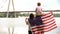 Family wrapped in American flag looking at bridge, immigration for better life