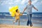Family with yellow balloons playing on the beach