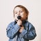 The famous actress. Humorous photo baby girl singing with a microphone (creativity, music, success concept)