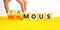 Famous or anonymous symbol. Concept word Famous and Anonymous on wooden cubes. Businessman hand. Beautiful yellow table white