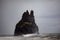 Famous basalt sea stacks of Reynisdrangar, rock formations on the black sand of Reynisfjar beach, view not far from Vik, a small v