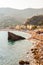 The famous beach full of deckchairs, sun umbrellas parasols, sunbathing and swimming tourists in Monterosso Al Mare, Cinque Terre