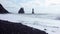 The famous black beach in Iceland, with black basaltic rocks of whimsical shape.