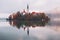 Famous Bled Lake in Triglav National Park in the Julian Alps with a forest in autumn colors at sunrise