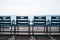 Famous blue chairs on the Promenade des Anglais of Nice, France against the backdrop of the blue sea.