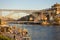 Famous bridge Ponte Luis in Porto bottom view. Riverside near giant steel bridge with people and boats.