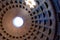 The famous cassette ceiling dome of Pantheon temple of all the gods with wide open rotunda on the top. Sunlight rays penetrating