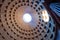 The famous cassette ceiling dome of Pantheon temple of all the gods with wide open rotunda on the top. Sunlight rays penetrating