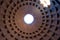 The famous cassette ceiling dome of Pantheon temple of all the gods with wide open rotunda on the top. Sunlight rays penetrating