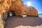 Famous caves in a beach rock formation in Algarve, Portugal. After two caves you can see the ocean, the sun is shining above the