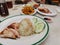 Famous chicken rice the staple food of Malaysia with mixed vegetable and crispy sliced fried pork.