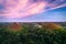 The famous Chocolate Hills of Bohol during sunset with whispy purple clouds and a cloudy fog drenched forest below