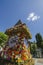 The famous clock tower, one of the city of Graz attractions, made of flowers and the real Clock Tower Grazer Uhrturm in the