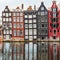 Famous dancing houses and buildings in Amsterdam with reflection in canal water