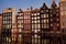 Famous dancing houses of the Damrak canal in Amsterdam on dusk