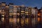 Famous dancing houses of the Damrak canal in Amsterdam at night