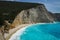 Famous empty hellenic beach on a sunny spring day with a turquoise sparkling sea under the woody cliff