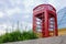 Famous English red telephone booth with cloudy day.