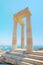 Famous Greek temple pillar against clear blue sky and sea in Greece