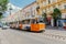 Famous historic yellow tram riding down city street in Budapest