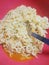 Famous home made asian instant noodle in a porcelain bowl with fork and spoon Close up