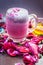 Famous Indian & Asian Summer and Ramadan drink i.e. Gulab shake or Rose falooda in a glass on wooden surface.