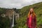 The famous Indonesia Sipiso Piso waterfall on Toba Lake, among the jungle and European young Caucasian girl tourist