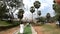 The famous landmark of Buddhism is a huge white stupa. pilgrims walk along a green path along palm trees