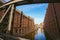 Famous landmark old Speicherstadt in Hamburg, build with red bricks. Bridge in low angle view