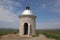 A famous little stony chapel at the top of the hill with blue sky above