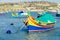 Famous multicolored fisherman`s boats in Marsaxlokk - traditional fishing village, Malta