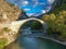 The famous old stoned bridge of Konitsa over Aoos river. Tymfi mount, Zagori, Epirus, Greece, Europe