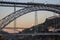 Famous Porto bridge Ponte Luis with train in the evening bottom view. Porto bridge in twilight with moon on background.