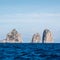 Famous sea stacks with arch, faraglioni, off the coast of Capri in the Bay of Naples on the Mediterranean Sea, Italy.