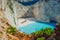 Famous shipwreck on Navagio beach with turquoise blue sea water surrounded by huge white cliffs. Famous landmark