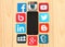 Famous social media icons around iPhone on wooden background