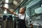 Famous soup. SIde view of attractive bald chef in apron taking a ladle for soup cooking while standing in a restaurant