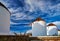 Famous tourist attraction of Mykonos, Greece. Three traditional whitewashed windmills by waterfront. Summer, travel