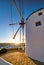 Famous tourist attraction of Mykonos, Greece. Traditional whitewashed windmill. Summer, sunrise, blue sky. Travel