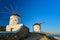 Famous tourist attraction, Mykonos, Greece. Two traditional whitewashed windmills. Summer, morning, clear blue sky