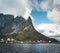 Famous tourist attraction of Reine in Lofoten with view towards Reinebringen, Norway with red rorbu houses, clouds